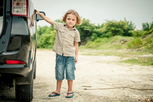 Маленький мальчик, стоящий возле машины — стоковое фото