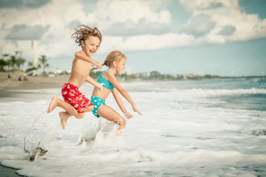 Two happy children  playing on the beach