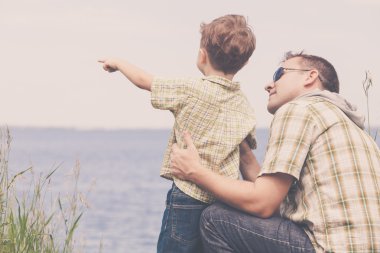 Baba ve oğul gün anda lake yakınındaki parkta oynamak.