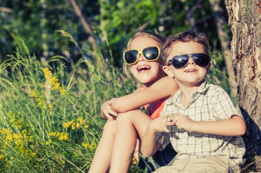 Ağacın yanında oynayan iki mutlu çocuk