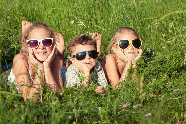 Três crianças felizes brincando no parque — Fotografia de Stock