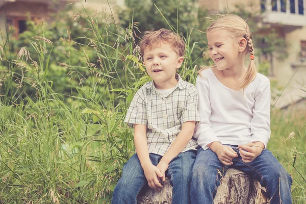 Deux enfants heureux jouant près de l'arbre — Photo