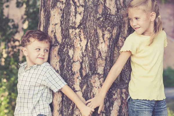 Dos niños felices jugando cerca del árbol — Foto de Stock