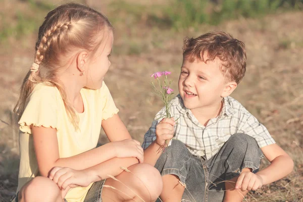 Duas crianças felizes brincando perto da árvore — Fotografia de Stock