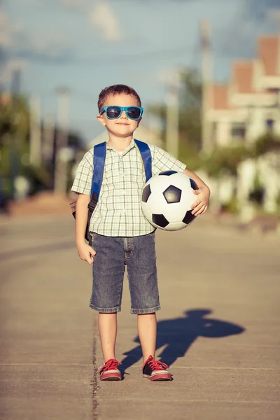 Kaukasischer kleiner Junge steht auf der Straße und hält seinen Fußball — Stockfoto