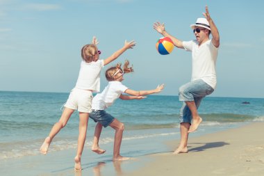 Baba ve kızı sahilde günbatımı anda oynamak. 