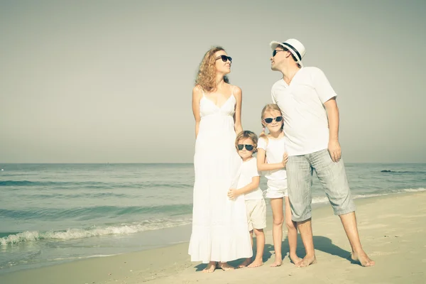 Felice famiglia a piedi sulla spiaggia durante il giorno . — Foto Stock
