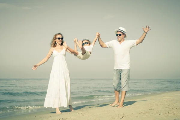 Gelukkige familie wandelen op het strand op het moment van de dag. — Stockfoto