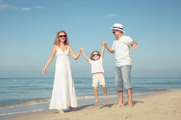 Gelukkige familie wandelen op het strand op het moment van de dag. — Stockfoto