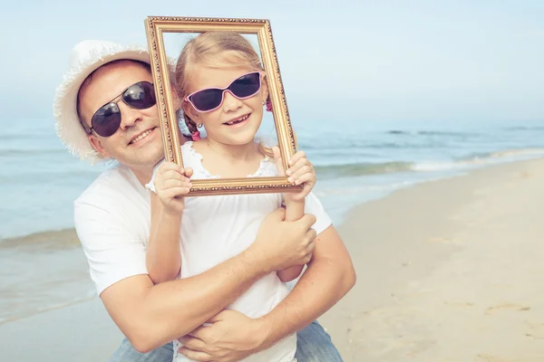 Padre e figlia che giocano sulla spiaggia durante il giorno . — Foto Stock