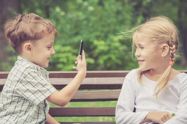 Zwei glückliche Kinder, die tagsüber im Park spielen. — Stockfoto