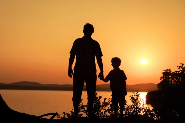 Vader en zoon spelen op de kust van lake — Stockfoto