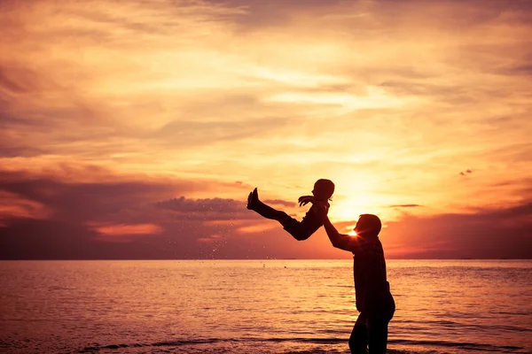 Отец и сын играют на пляже на закате . — стоковое фото