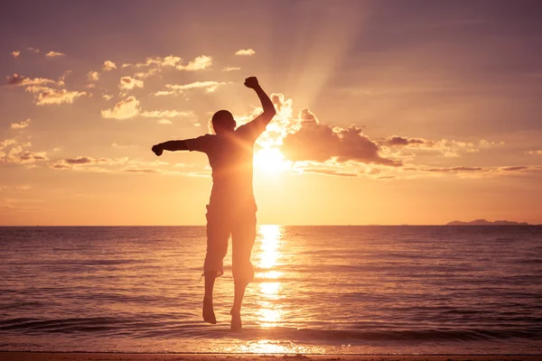 Man met zijn handen omhoog op het strand — Stockfoto