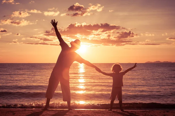 Padre e figlio che giocano sulla spiaggia all'ora del tramonto . — Foto Stock