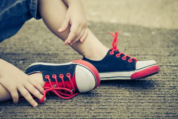 Zapatillas de deporte juveniles en piernas de niño en el camino — Foto de Stock