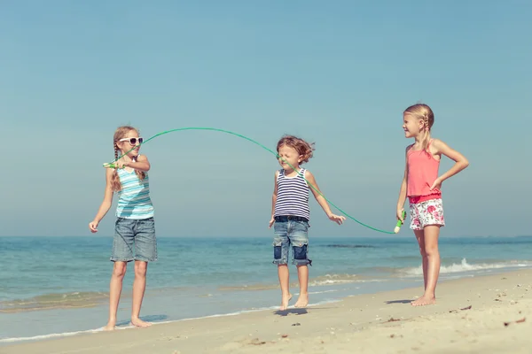 Троє щасливих дітей грають на пляжі — стокове фото