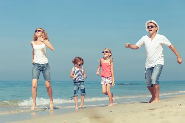 Lyckliga familjen promenerar på stranden på dagarna. — Stockfoto