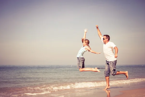 Padre e figlia che giocano sulla spiaggia durante il giorno . — Foto Stock