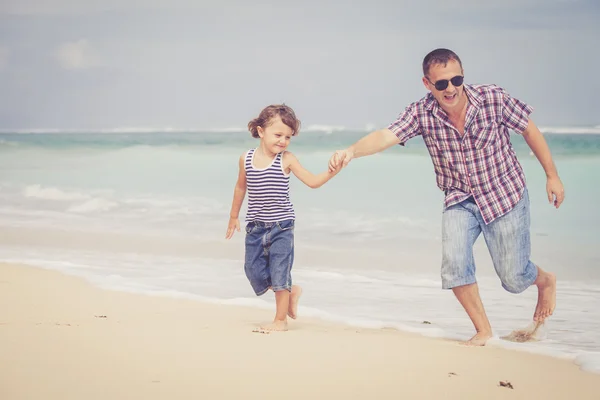 Vader en zoon spelen op het strand op het moment van de dag. — Stockfoto