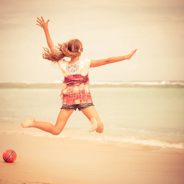 Gelukkig tiener meisje springen op het strand — Stockfoto