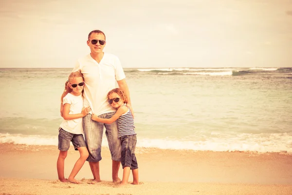 Vader en kinderen spelen op het strand op het moment van de dag. — Stockfoto