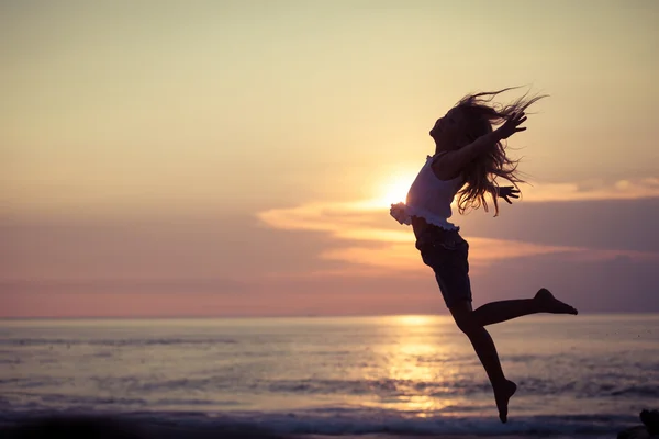 Glückliches kleines Mädchen springt am Strand — Stockfoto