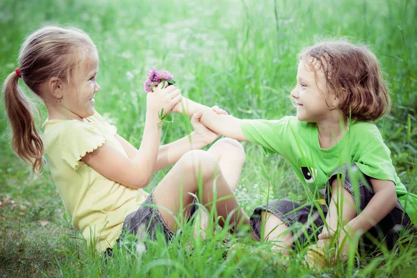 两个快乐的孩子们，在白天的时间附近的树上玩. — 图库照片