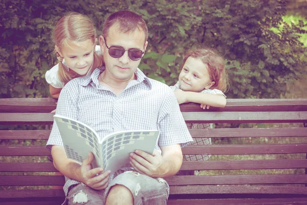 Père et enfants jouant sur le banc le jour . — Photo