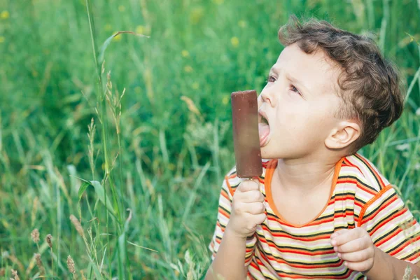 公園でアイスクリームを食べてる男の子 — ストック写真