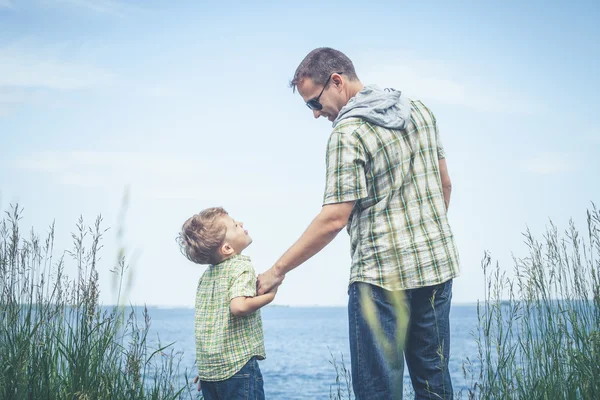 Far och son började spela på park nära lake med dagen. — Stockfoto