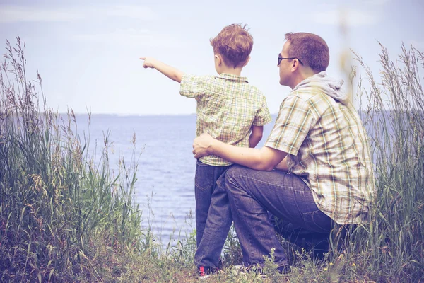 Vater und Sohn spielen tagsüber im Park am See. — Stockfoto