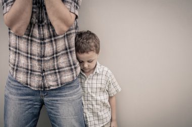 üzgün oğlu, babasının duvarının yakınında sarılma