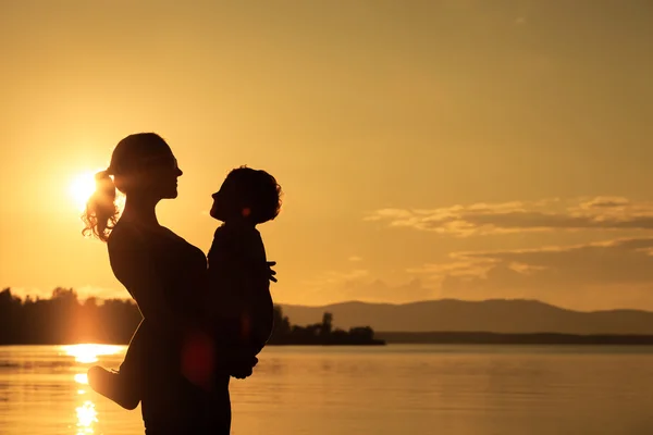 Mor och son spelar på kusten av sjön — Stockfoto