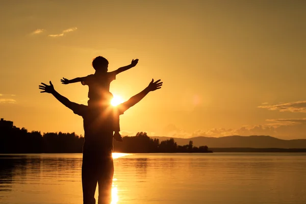 Батько і син грають на узбережжі озера — стокове фото