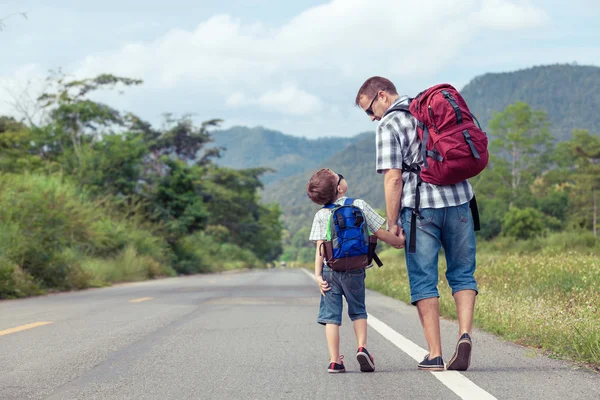 Pai e filho caminhando na estrada . — Fotografia de Stock