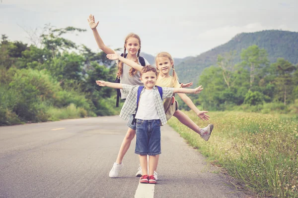 De gelukkige kinderen lopen op de weg. — Stockfoto