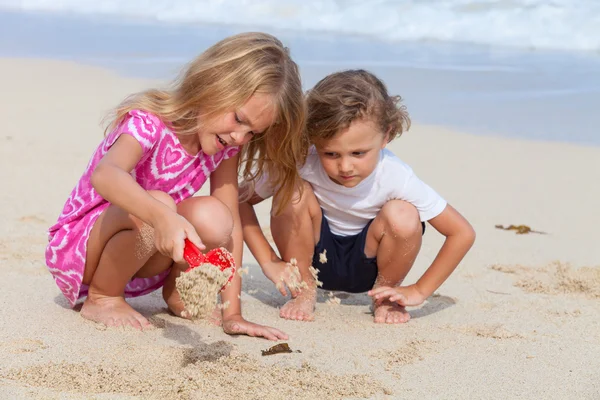 Dwa szczęśliwe dzieci bawiące się na plaży — Zdjęcie stockowe