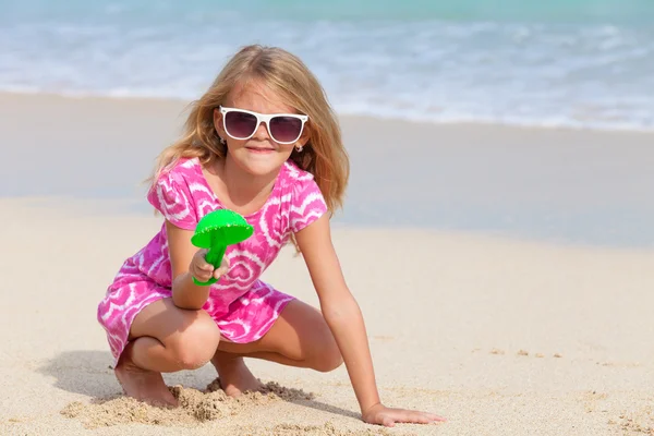 Glad liten flicka som leker på stranden — Stockfoto