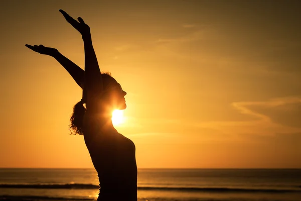 Woman open arms under the sunset at sea — Stock Photo, Image