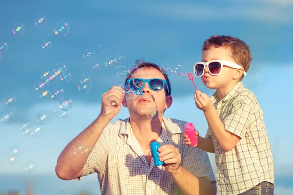 Vader en zoon spelen in het park op het moment van de dag. — Stockfoto