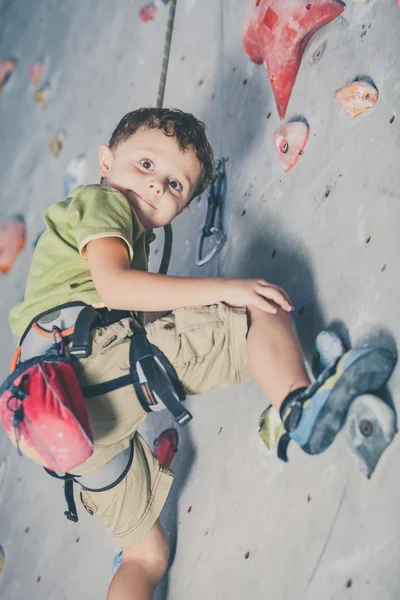 Menino escalando uma parede de pedra — Fotografia de Stock