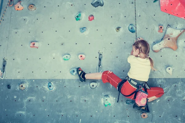 Petite fille escalade un mur de roche — Photo