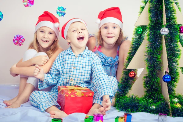 Счастливый маленький улыбающийся мальчик и девочки в рождественской шляпе . — стоковое фото