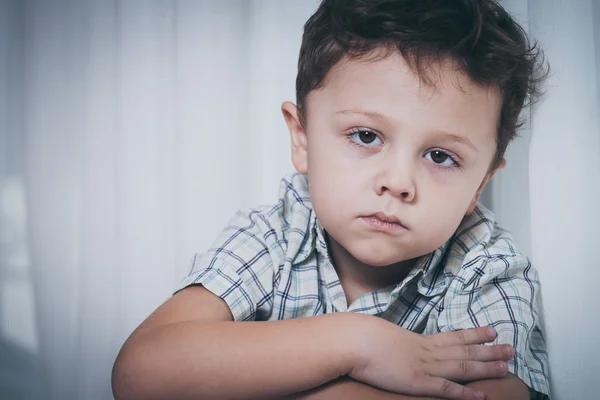 Portret smutny chłopiec siedzący obok okna — Zdjęcie stockowe