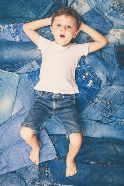 Cute little boy  the background jeans. — Stock Photo, Image