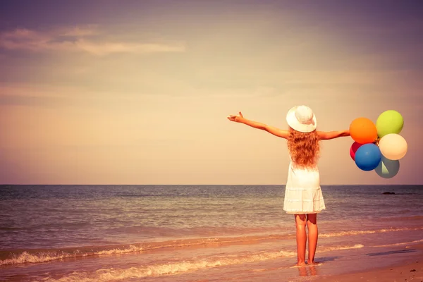 Teen girl with balloons standing on the beach — Stock Photo, Image