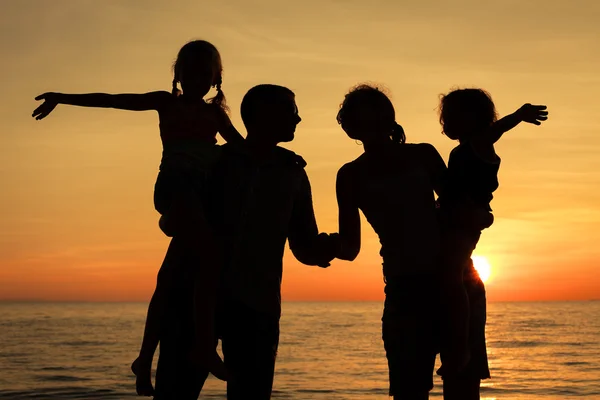 Sylwetka szczęśliwy rodziny grający na plaży w sunse — Zdjęcie stockowe
