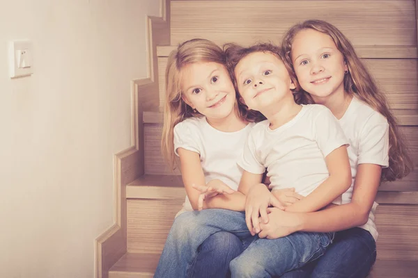 Portrait of happy children which are sitting on the stairs in th — Stock Photo, Image