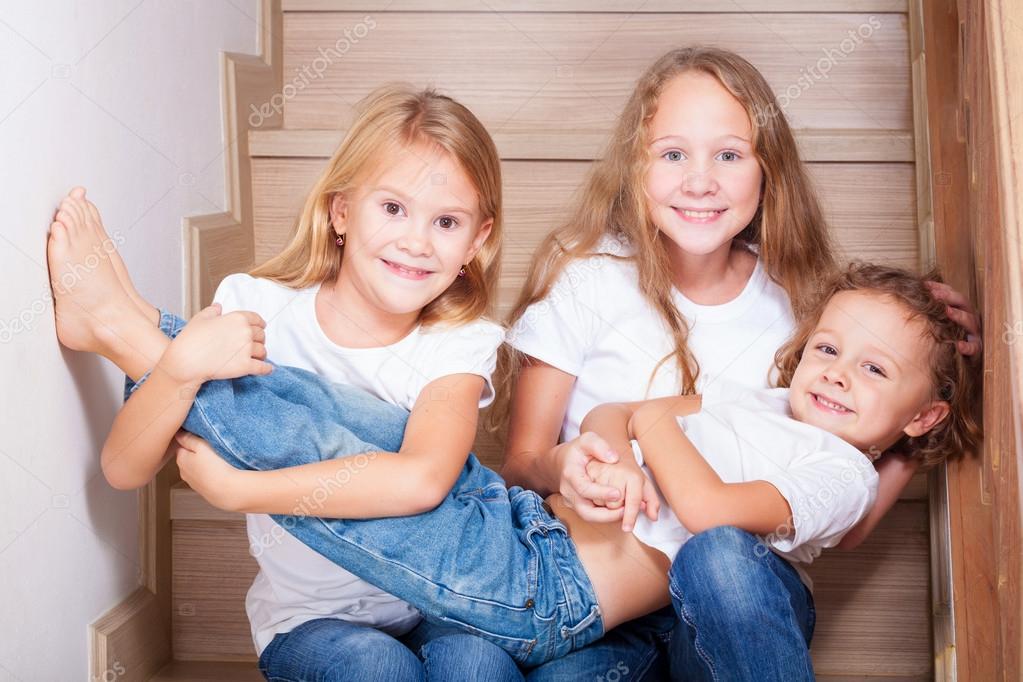 Portrait of happy children which are sitting on the stairs in th